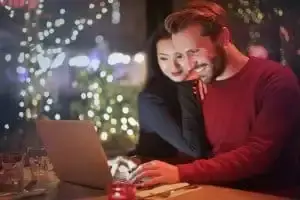 Stel volgt intensieve online relatietherapie achter de laptop aan de keukentafel.